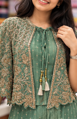 Close up of gold-toned floral embroidery and tassel neckline
